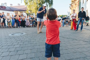 4 Ağustos 2018 Akşam kentte sokak şenlikleri Mikrofonlu küçük bir çocuk bir sokak konserinde insanlara bakıyor