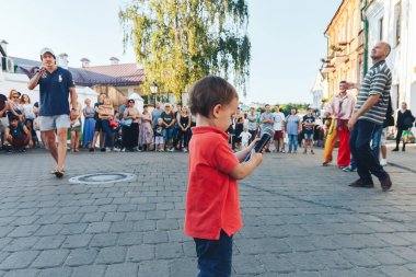 4 Ağustos 2018 Akşam kentte sokak şenlikleri Mikrofonlu küçük bir çocuk bir sokak konserinde meydanda duruyor