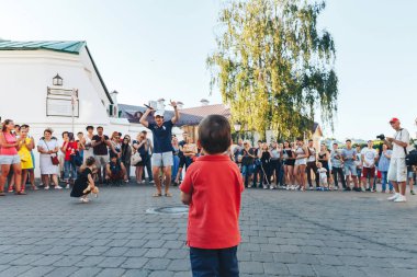 4 Ağustos 2018 Akşam kentte sokak şenlikleri Küçük bir çocuk babası şarkı söylediğinde sokak konserinde duruyor