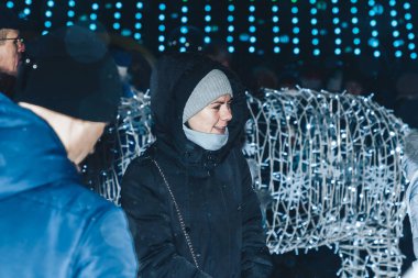 29 Aralık 2018 Akşam şehrinde Minsk Belarus Caddesi şenlikleri Bir erkek ve bir kadın parlayan bir figürün yanında duruyor.