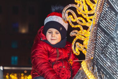 30 Aralık 2018 Minsk Belarus Yeni Yıl kutlamaları şehir meydanında. Küçük bir çocuk yeni yıl tatili sırasında meydanda parlayan bir at üzerinde oturur.