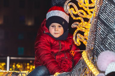 30 Aralık 2018 Minsk Belarus Yeni Yıl kutlamaları şehir meydanında. Küçük bir çocuk meydanda parlayan bir atın üzerinde oturuyor. Yakın çekim
