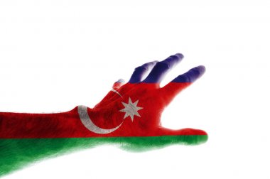 Azerbaycan bayrağının renklerine boyanmış olgun bir adamın eli, 28 Mayıs'ta Azerbaycan'ın Bağımsızlık Günü'ne adanmış soyutlamayı parmaklarıyla öne doğru uzatır..