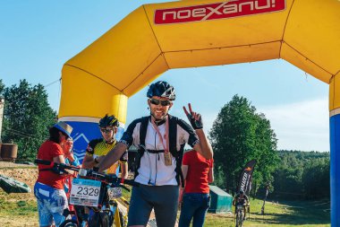 May 26-27, 2018 Naliboki,Belarus All-Belarusian amateur marathon Naliboki Male cyclist with a bicycle and a medal standing at the finish