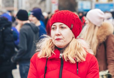 23 Şubat 2019 Minsk Belarus 23 Şubat'ta tatil onuruna yarışan kırmızı şapkalı ve ceketli bir kadın halk arasında duruyor.