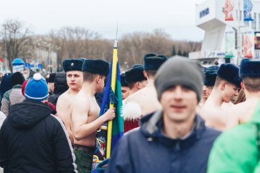 23 Şubat 2019 Minsk Belarus 23 Şubat'ta tatil onuruna yarış askerler bir tatil de sokakta yürüyen insanlar arasında bir bayrak standı ile çıplak gövde ile