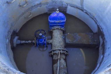 Boru hattı elemanları, plastik borular, beton stop, inşaat alanında bir beton kuyuda dökme demir vana Yakın