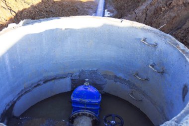 Boru hattı elemanları, plastik borular, beton kuyuda dökme demir vana. Kuyudan çıkan plastik boru