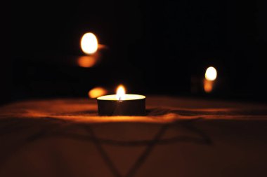 Ölülerin anısına Davut 'un Yıldızı' nın üzerinde yanan mumlar..