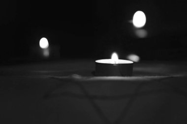 Ölülerin anısına Davut 'un Yıldızı' nın üzerinde yanan mumlar..