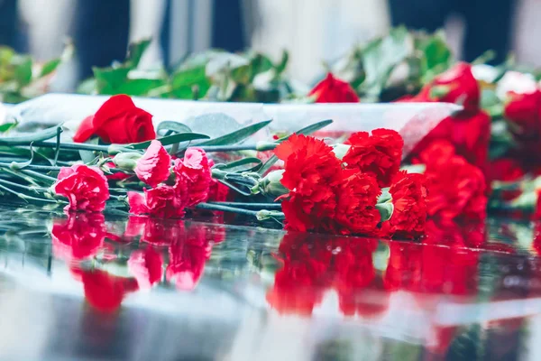 Rosas rojas yacen en el granito negro — Foto de Stock