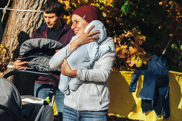 14 Ekim 2018, Minsk, Belarus.2018 Olimpiyat Kros Kupası Xco Medvezhino Anne kollarında küçük bir çocuk ile sonbahar ormanında gülümsüyor