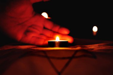 Keder gününde siyah bir arka plan üzerinde Davud Yıldızı üzerinde yanan mumlar. Yahudi soykırımı kurbanlarının anısına bir sembol