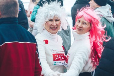 9 Şubat 2019 Minsk Belarus Koşusu 14 Şubat'a adanmış iki olgun kadın kırmızı beyaz saçlı ve kostümlü iki olgun kadın insanlar arasında gülüyor