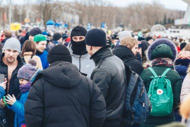 23 Şubat 2019 Minsk Belarus 23 Şubat'ta tatil onuruna yarış anons yüzünde maskeli bir adam yürüyen insanlar arasında sokakta duruyor