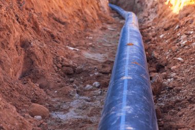 Eve su beslemek için mavi şeritli siyah plastik bir boru