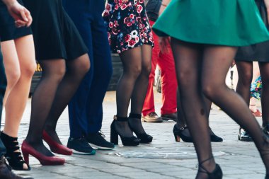 Young and beautiful actors are dancing on the street.