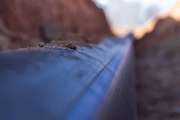 Tubería de agua de plástico yacía en una zanja — Foto de Stock