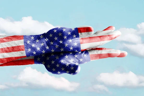 Dos palmas pintadas en los colores de la bandera de Estados Unidos yacen una encima de la otra contra el cielo azul . — Foto de Stock