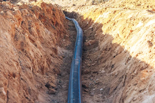 Plastic water pipe lay in a trench — Stock Photo, Image
