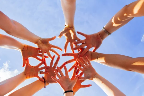 Bir çok kadın eli gökyüzünün arka planında