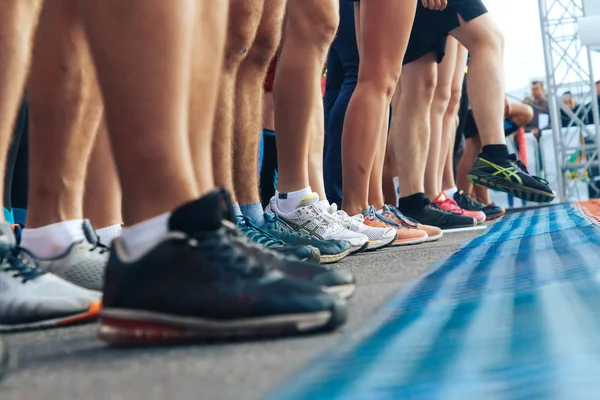 Marathon runners stand on the road in front of the start line — Stock Photo, Image