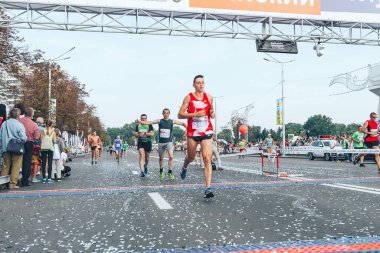 9 Eylül 2018 Minsk Belarus Yarı Maraton Minsk 2018 Bir maraton koşucusu bitiş çizgisini katılımcıların önünde geçiyor