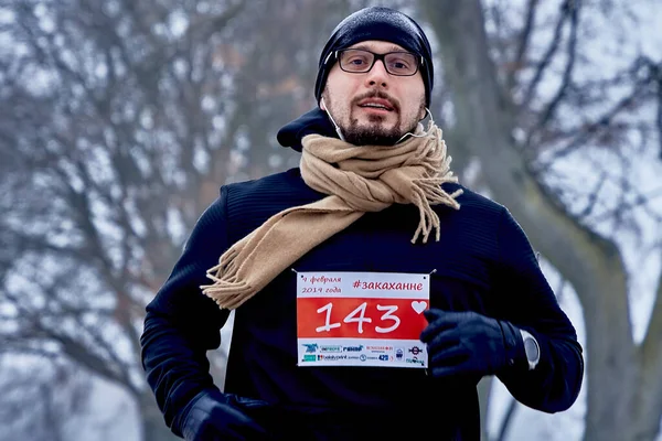 2019年2月9日白俄罗斯明斯克跑步 专门为2月14日一名戴眼镜男子的特写镜头冬季在公园的一条路上奔跑 — 图库照片