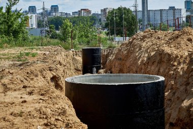 Su geçirmez mastikle kaplı beton duvarlar şehirde boru döşemek için bir siperde.