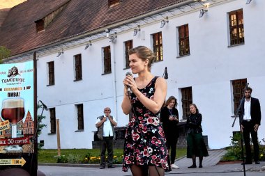 25 Mayıs 2019, Minsk Belarus. Bir sokak konserinde mikrofonlu mutlu genç bir kadın.