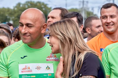 15 Eylül 2019 'da Minsk Belarus' ta bir kadın, mutlu sporcuların arasında bir adama şöyle der: