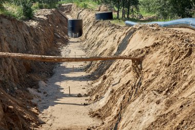 Güçlendirilmiş beton kuyu su geçirmez mastikle kaplıdır, boru döşemek için delik açılır. Su borularının döşenmesi ve yerleştirilmesi için hendek açılır..