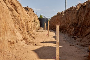 Siperlerde uzanmak için boru hattının tabanının yüksekliğini belirlemek için tahta kazıklar.