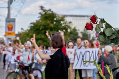 Red roses against the background of protesting people