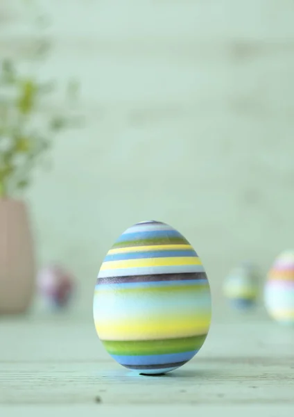 Un œuf de Pâques décoré sur une table en bois vert menthe — Photo