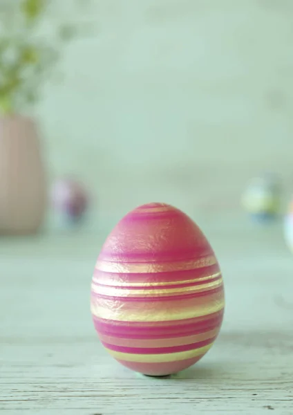 Un œuf de Pâques décoré sur une table en bois vert menthe — Photo