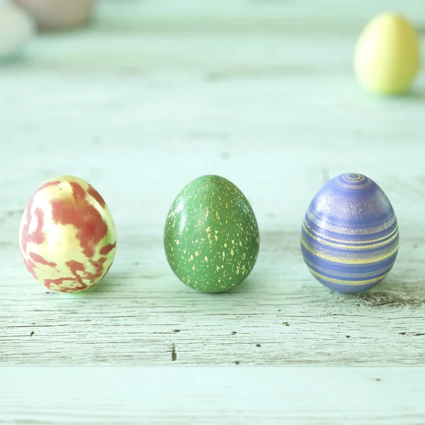 Trois œufs de Pâques colorés sur bois vert — Photo