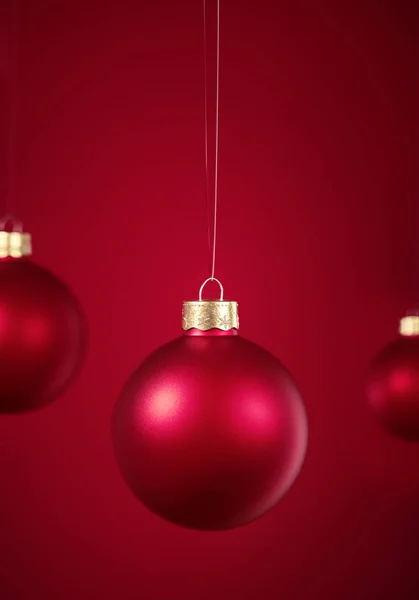 Christmas baubles hanging in front of red background. — Stock Photo, Image