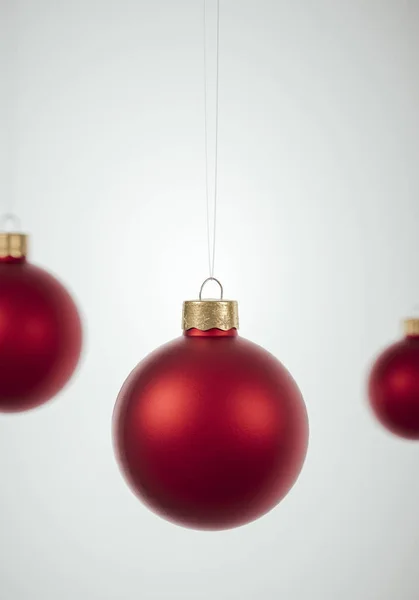 Rote Christbaumkugeln hängen vor rotem Hintergrund. — Stockfoto