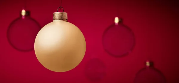 金色的圣诞球挂在玻璃球前 — 图库照片