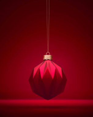 Kırmızı Matt Noel topu altın ipte sallanıyor. Modern geometrik desenli Noel süsü. Noel dekorasyonu, neşeli atmosfer konsepti.