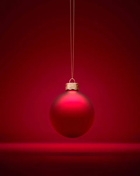 Kırmızı Matt Noel balosu, sarı ipin üzerinde koyu kırmızı arka planda asılı duruyor. Noel dekorasyonu, neşeli atmosfer konsepti.