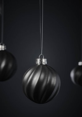 Üç çarpık çizgili siyah Noel topu koyu gri arka planda. Noel dekorasyonu, şenlikli atmosfer konsepti. Seçici odaklanma, portre yönelimi.