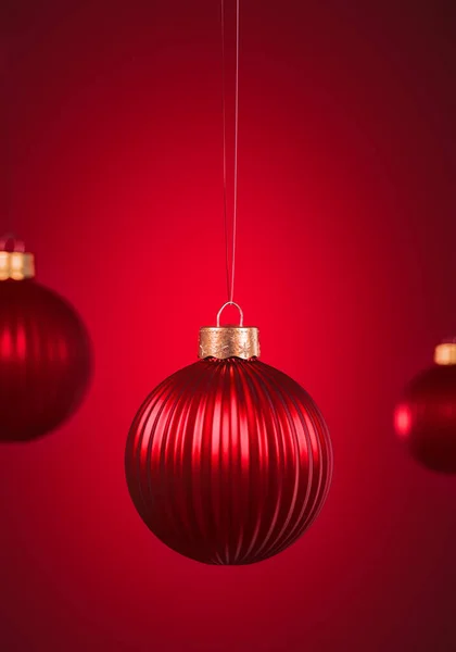 Verticaal Geribbelde Kerstballen Opknoping Tegen Rood Gekleurde Achtergrond Kerstversiering Feestelijk — Stockfoto