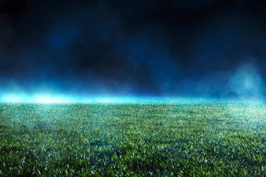 Night low view of maintained lawn at football stadium. Beams of light showing light effects at fog. clipart