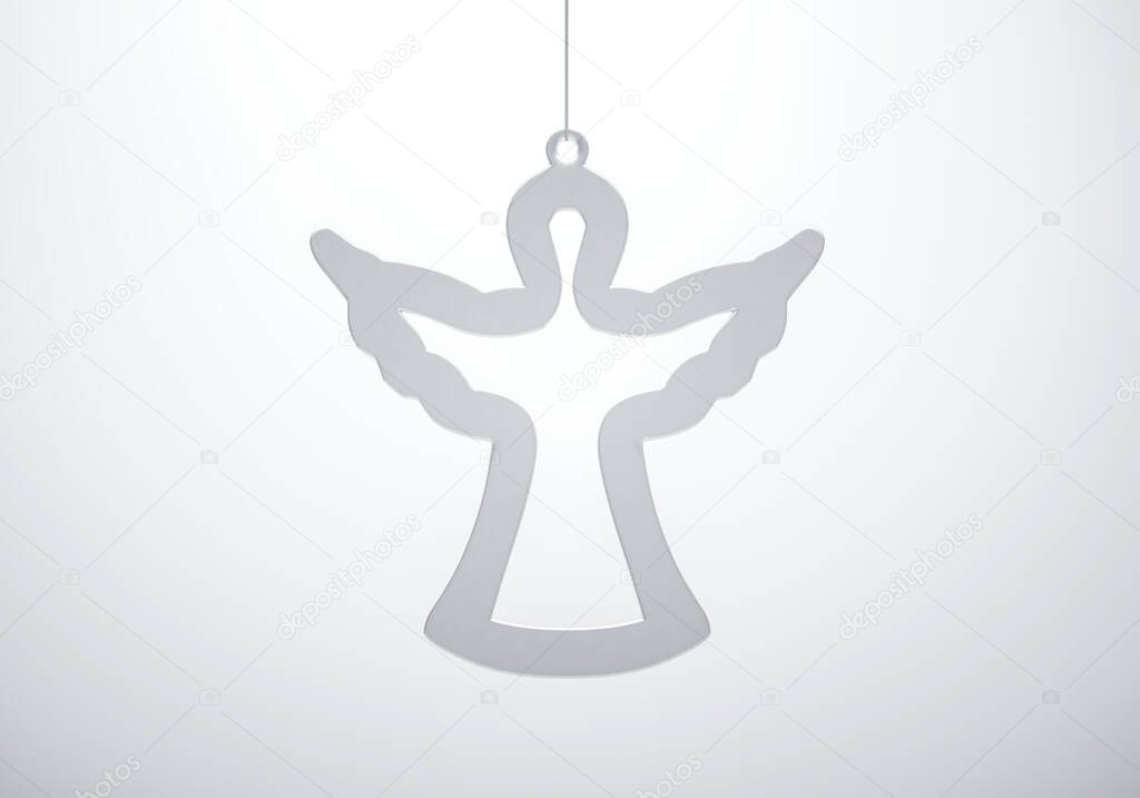 Glass angel contour Christmas ornament against white background. Christmas decoration, festive atmosphere concept.