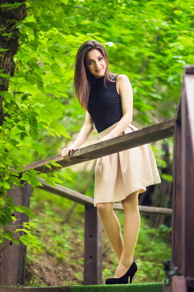 Młoda Piękna Dziewczyna Stwarzających Parku Miejskiego Pobliżu Piękne Drewniane Poręcze — Zdjęcie stockowe