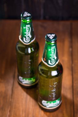 Kiev, Ukrayna - 05 Temmuz 2018: Carlsberg şişe bira ahşap arka plan üzerinde. Danimarkalı bira şirketi 1847 yılında kurulmuştur.