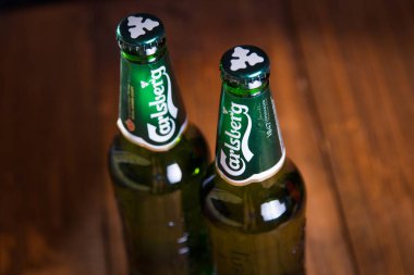 Kiev, Ukrayna - 05 Temmuz 2018: Carlsberg şişe bira ahşap arka plan üzerinde. Danimarkalı bira şirketi 1847 yılında kurulmuştur.
