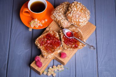 ahududu reçeli ve turuncu fincan çay ile bazı taze buns